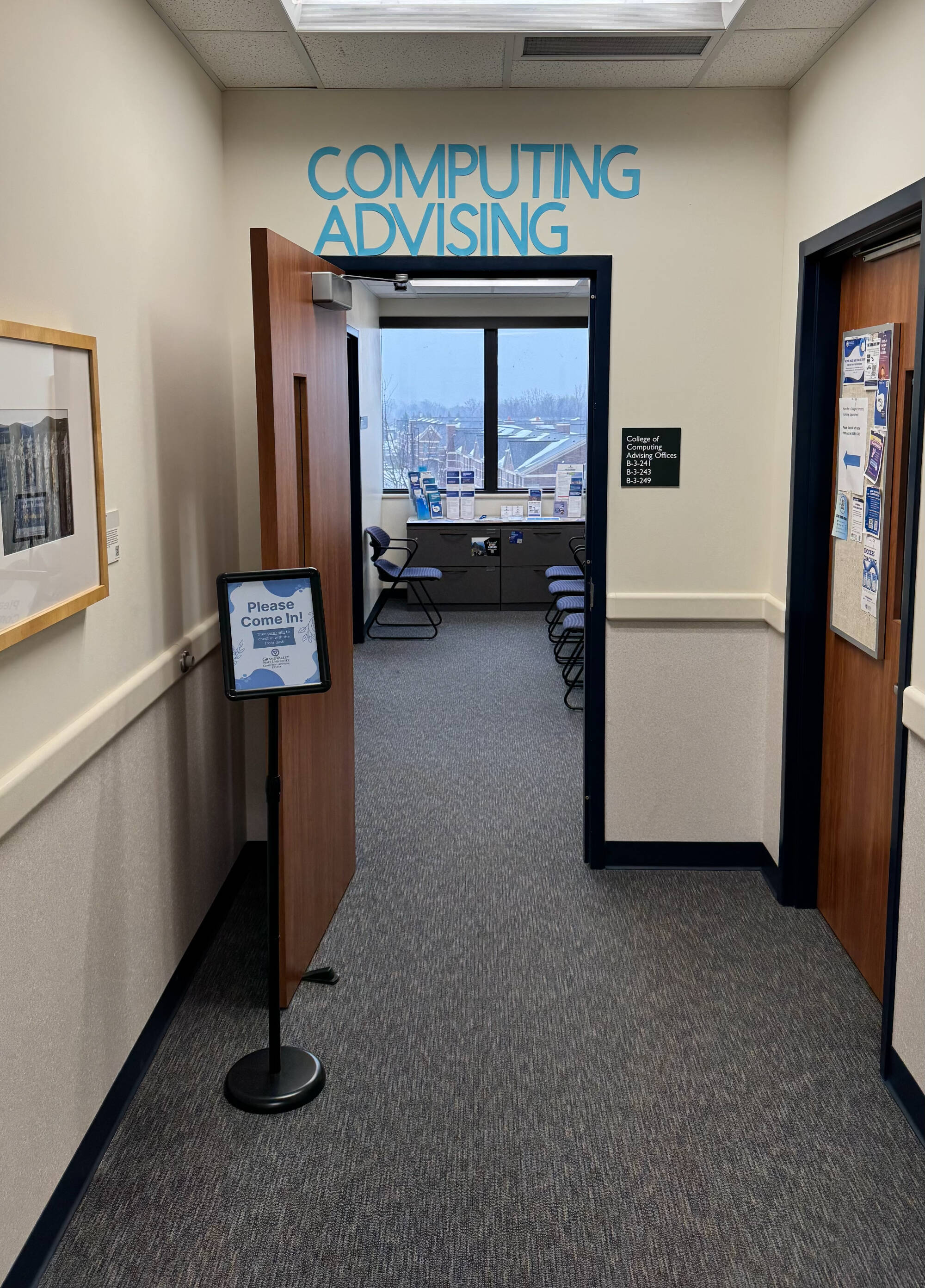 Brown door at the end of a hallway with "Computing Advising" in large letters above
